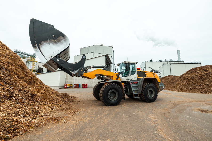 materiały partnera Koparka ładująca silos magazynowy na zrębki drzewne przy zakładzie przemysłowym - pojemność dostosowana do kotła na biomasę o mocy 200 kW